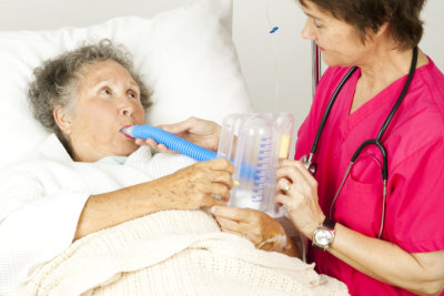 Nurse gives respiratory therapy to a patient recovering in the hospital