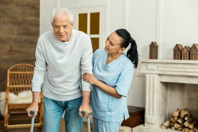 caregiver assisting the senior woman with walker
